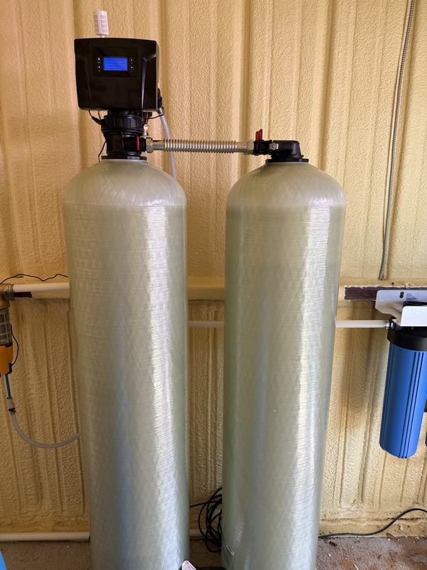 Chemical-free BIF iron and sulfur system: two tall fiberglass media tanks joined by a stainless connector under a single digital control valve, with a cartridge filter on the wall alongside